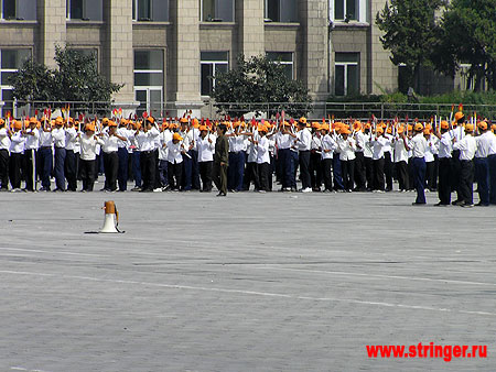Вблизи видно, что в руках у корейцев, репетирующих парад, символы факелов. Подготовка к параду занимает весь световой день...